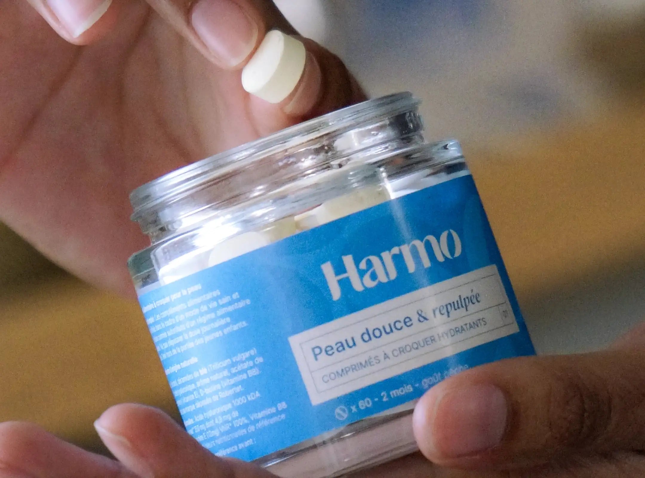 Pot de comprimés à croquer hydratant avec une main qui sort un comprimé Image