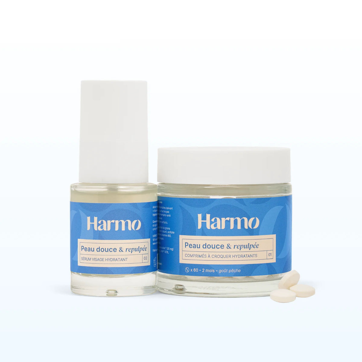 Routine Hydratante avec un sérum et pot de comprimés à croquer Harmo Peau douce et repulpée côte à côte sur fond neutre