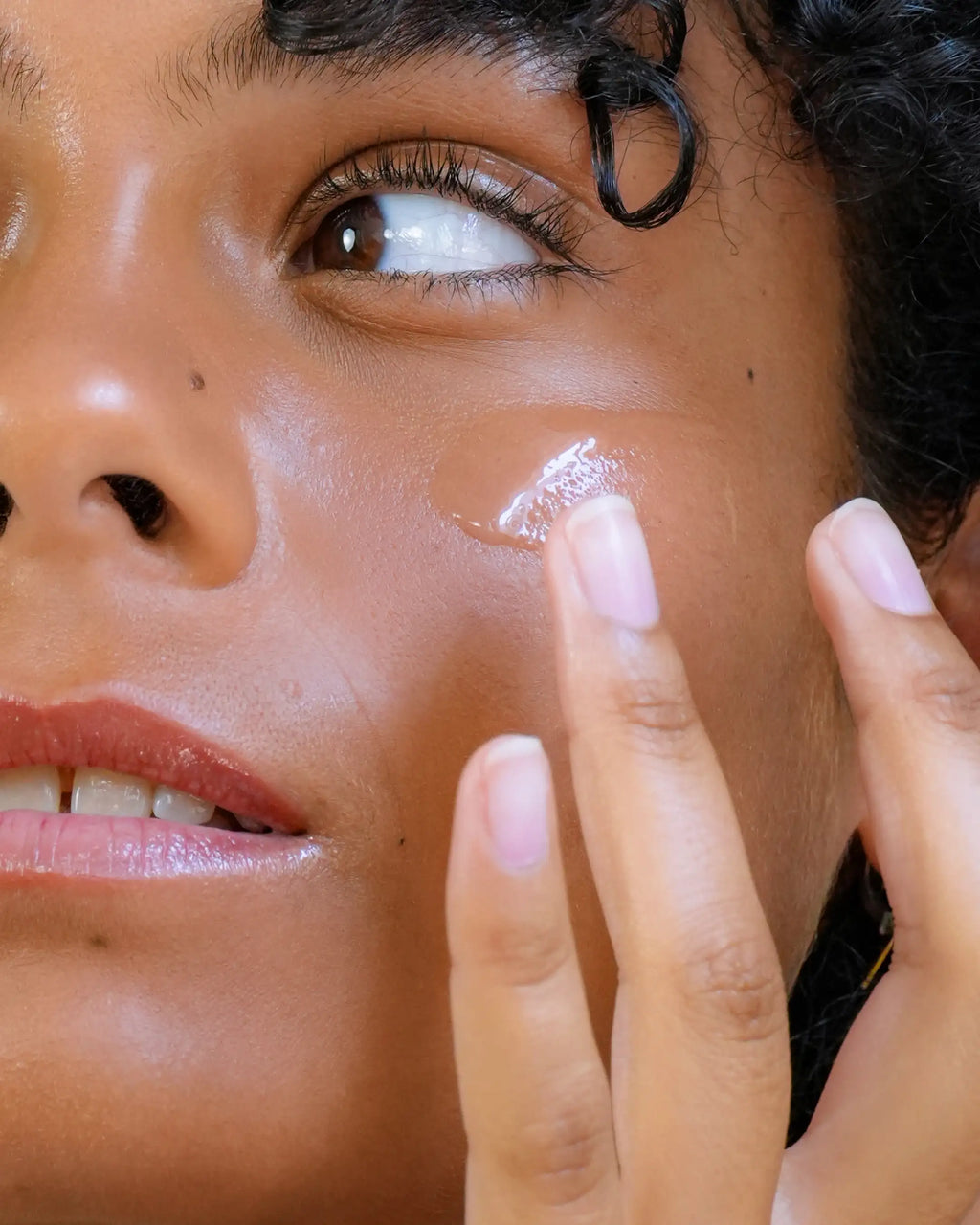 Femme appliquant le sérum Hydratant Harmo Peau douce et repulpée sur sa joue, zoom sur la texture