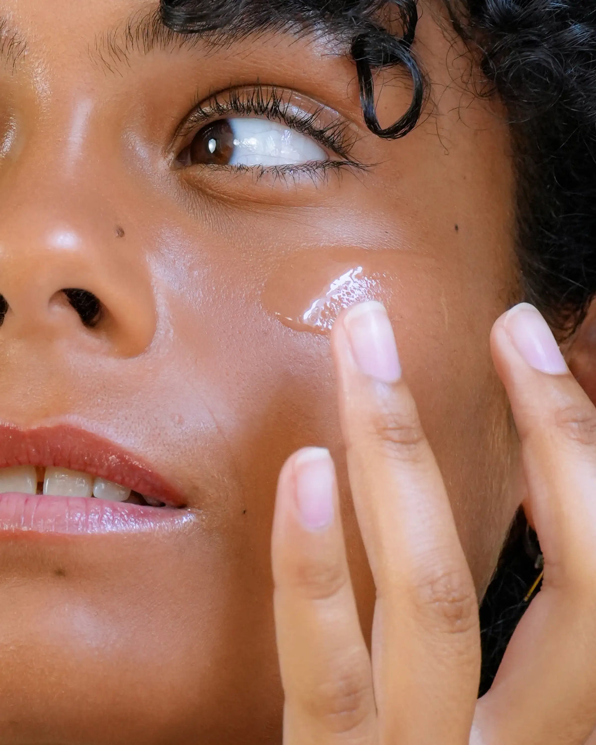 Femme appliquant le sérum Hydratant Harmo Peau douce et repulpée sur sa joue, zoom sur la texture