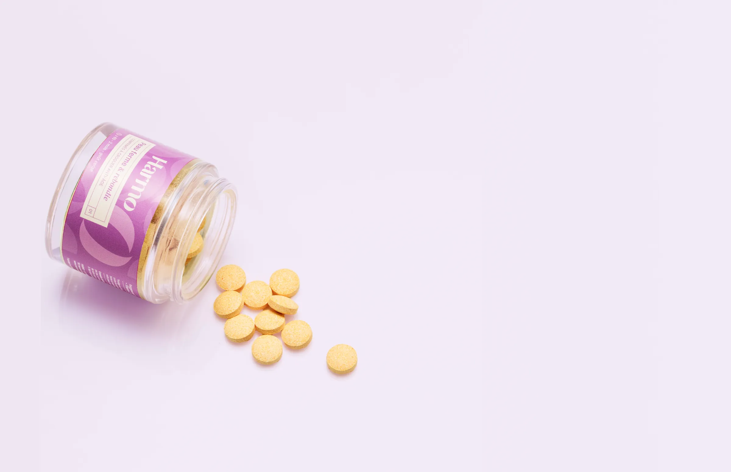 Pot de compléments anti-âge Harmo Skincare renversé avec comprimés à croquer goût cerise